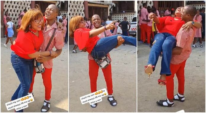 Strong secondary school boy lifts his mum like a baby