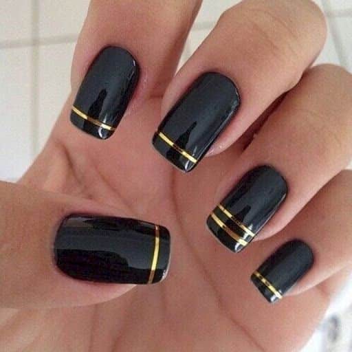 Black French tips with gold stripe accents