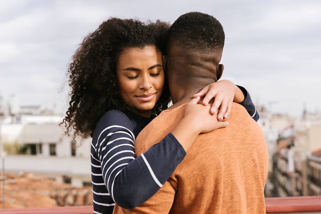 Beautiful black couple hugging on the terrace