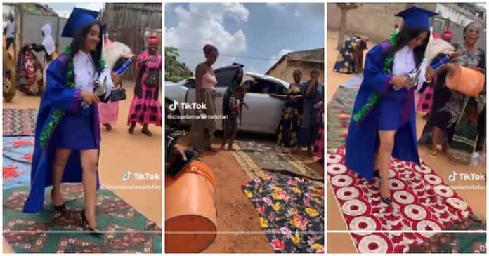 Proud women lay wrappers on the ground as fresh female graduate returns home