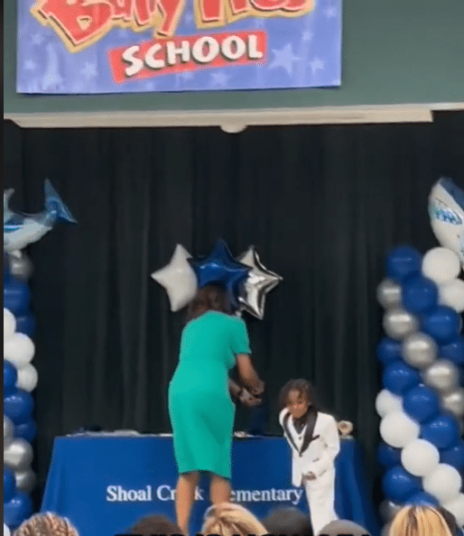 Young boy dances in jubilation as he graduates from kindergarten  