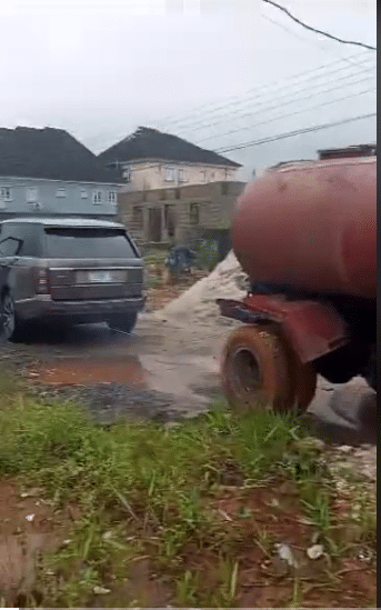 Man uses Range Rover car to pull a truck from mud
