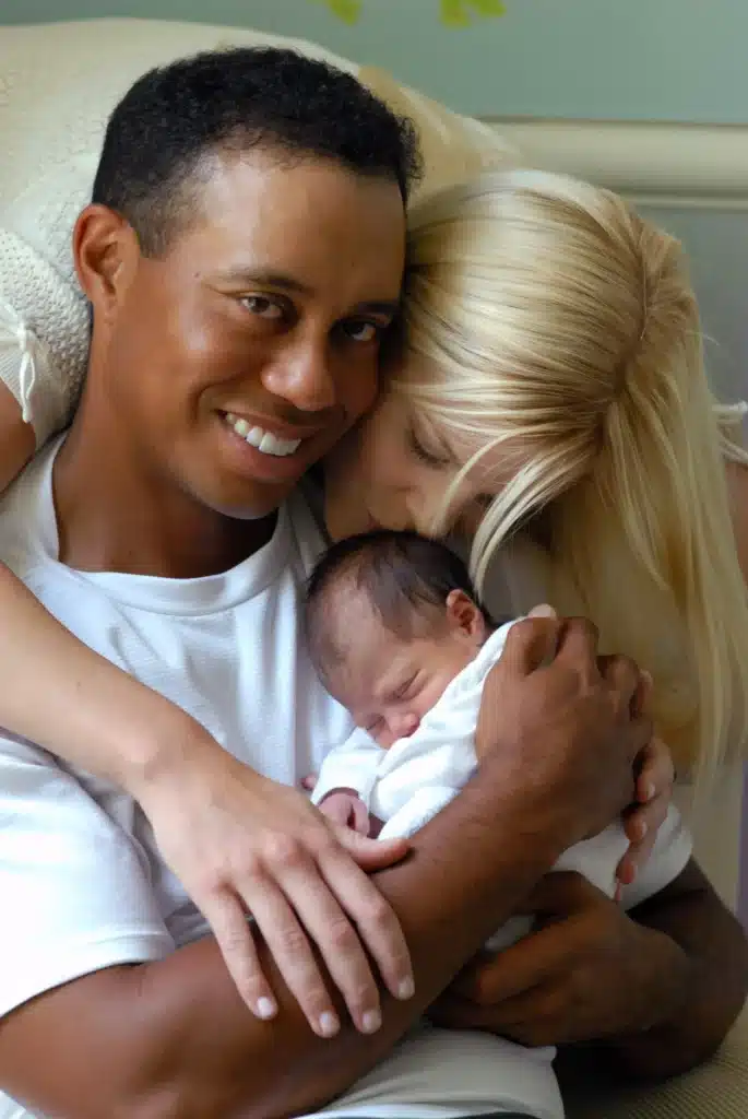 Tiger Woods holding his newborn daughter, Sam Alexis Woods, while Elin Nordegren kissing her baby's head