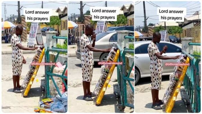Young man prays fervently before selling sunshades on busy road