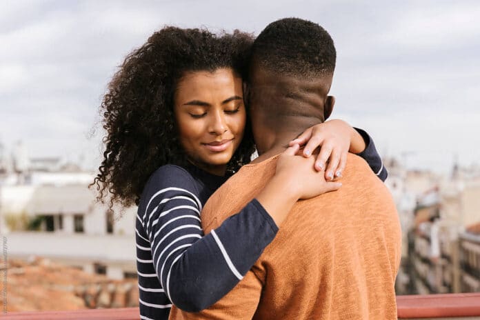 Beautiful black couple hugging on the terrace